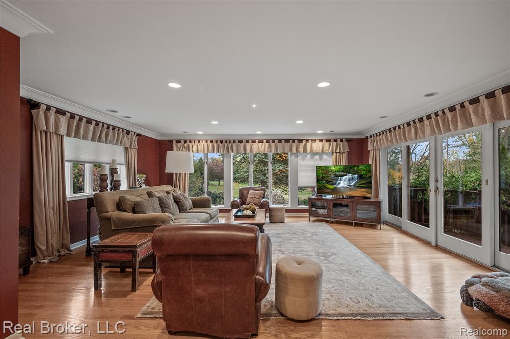 Living room featuring ornamental molding, light wood-style flooring, and recessed lighting