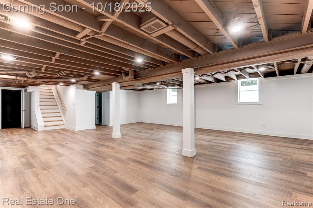 Basement with stairs and light wood-style flooring
