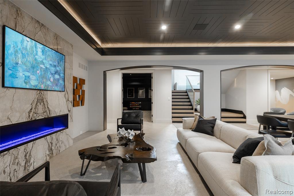 Living area featuring arched walkways, stairway, and a fireplace