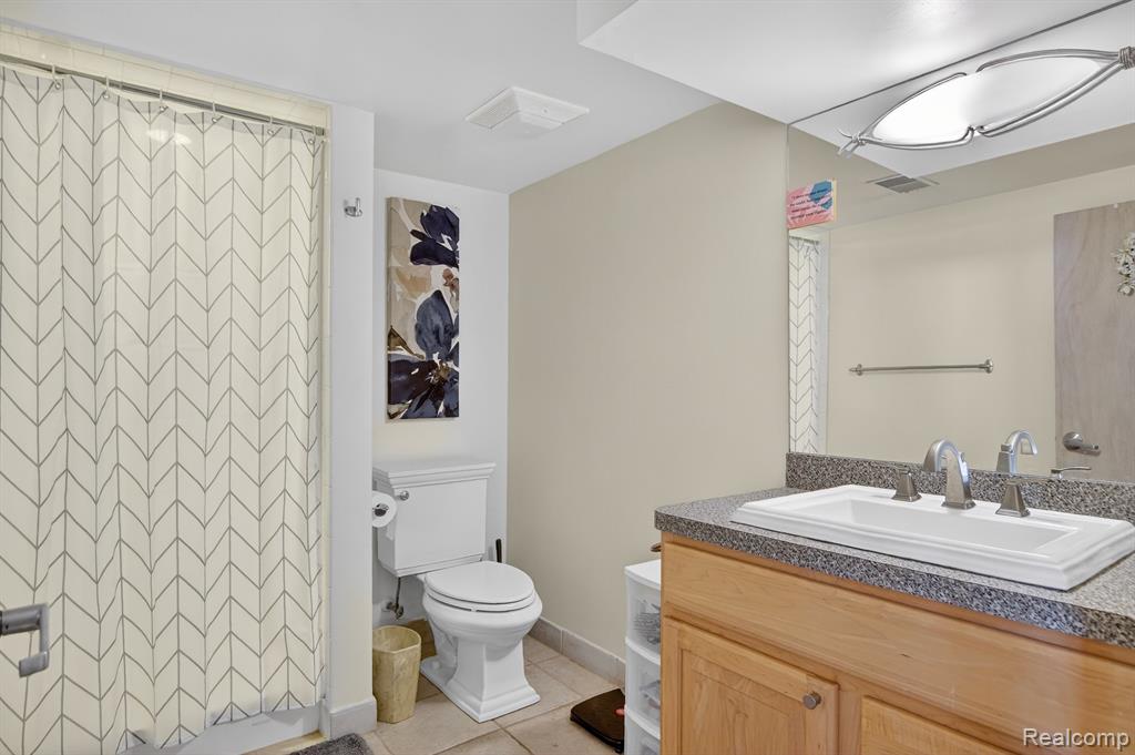 Half bathroom featuring vanity and a walk in closet