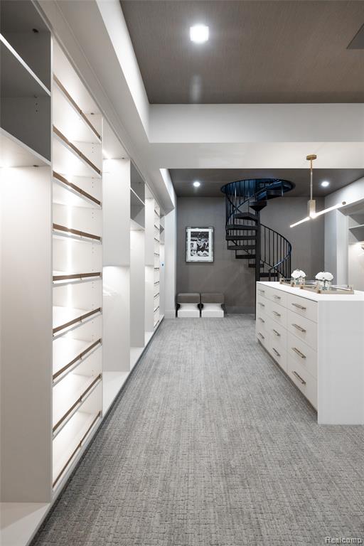 Walk in closet with light colored carpet