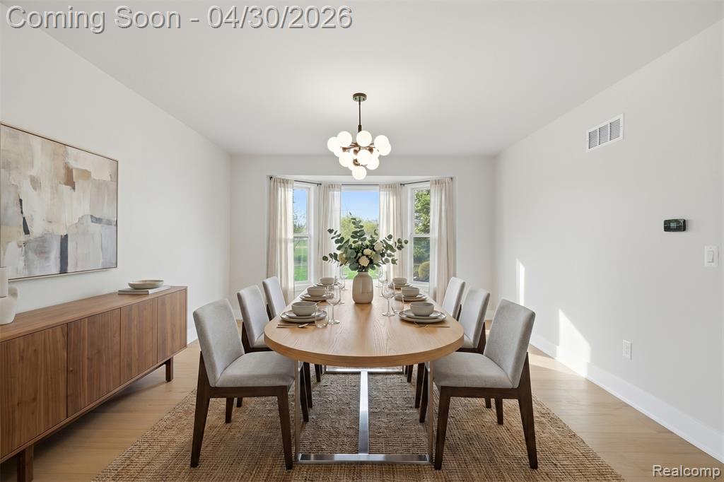 Dining area with light wood-style floors and hanging lights