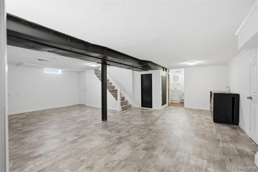 Basement featuring stairway and light wood-style flooring