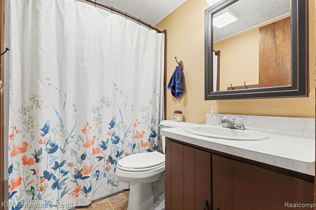 Full bath with vanity and a shower with shower curtain