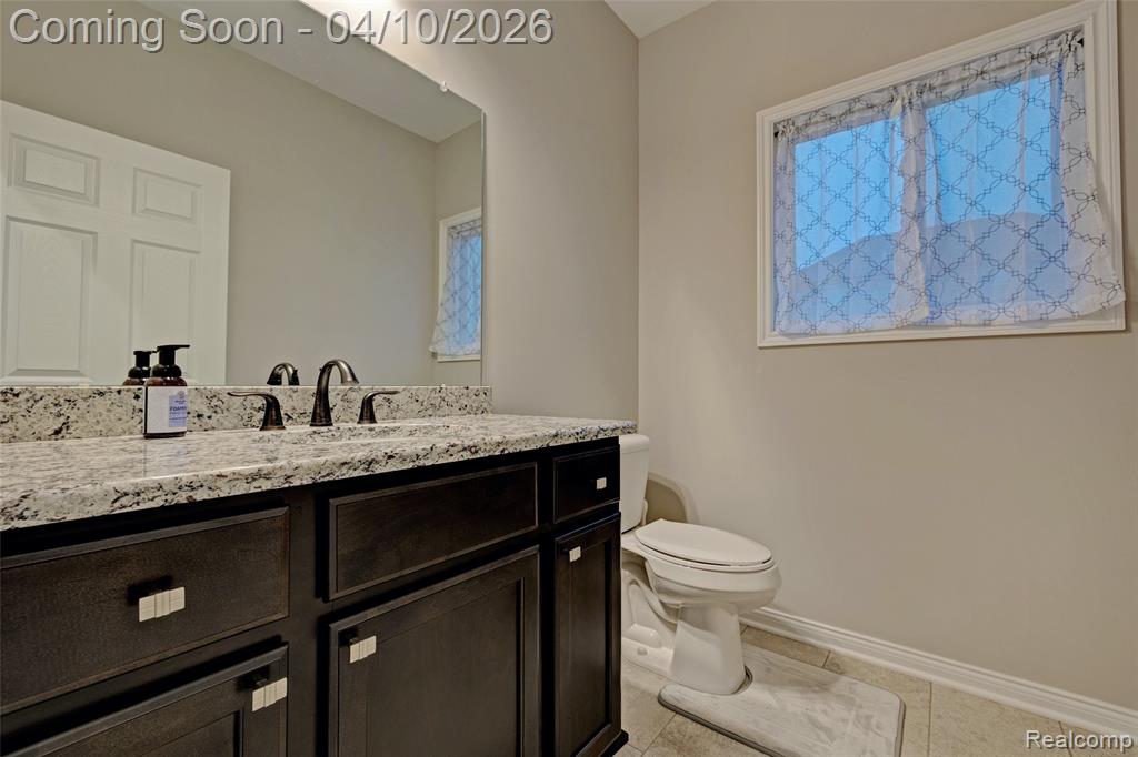 Half bath with vanity and light tile patterned floors