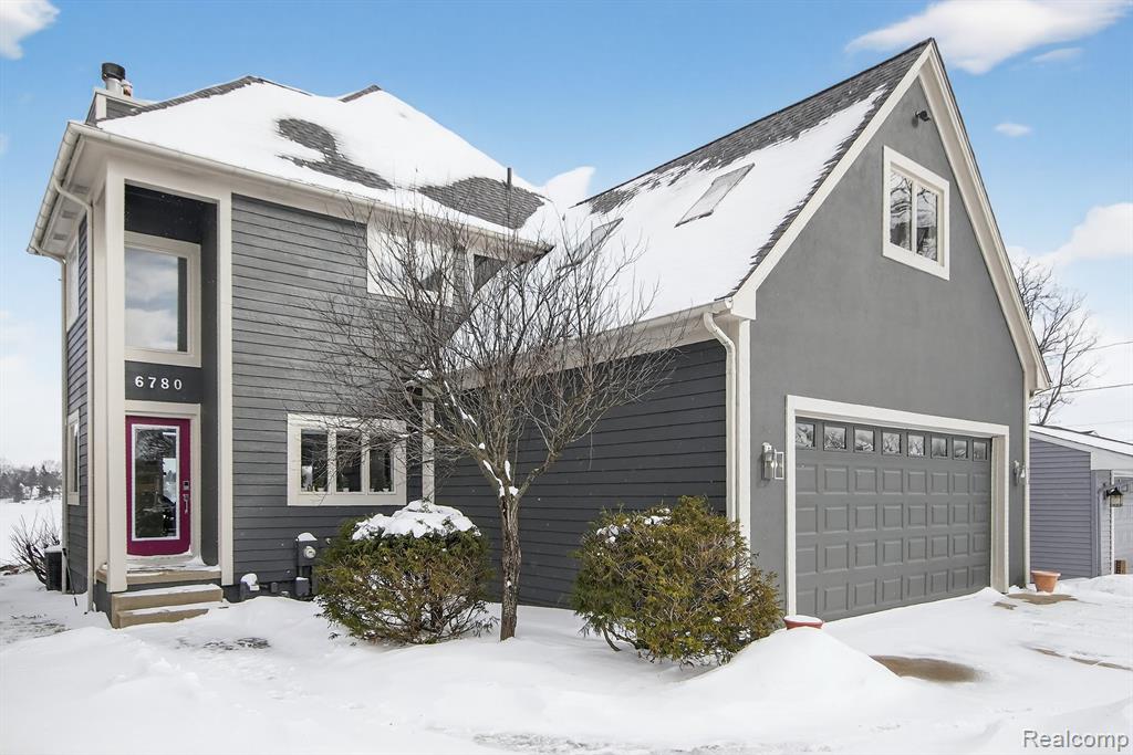 View of front of home featuring driveway, a garage, and stucco siding