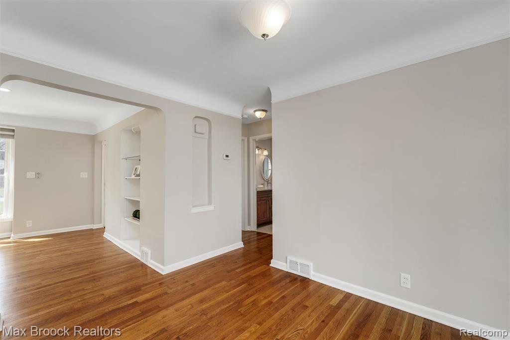 Empty room with built in shelves and wood finished floors