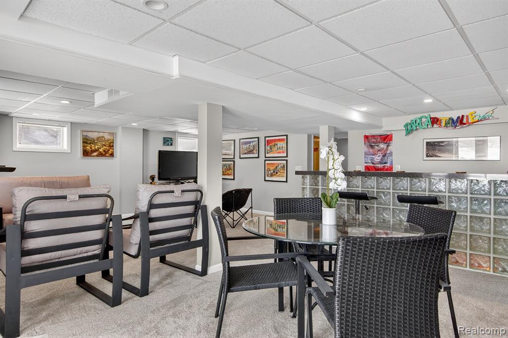 Dining space featuring carpet flooring, a paneled ceiling, and recessed lighting