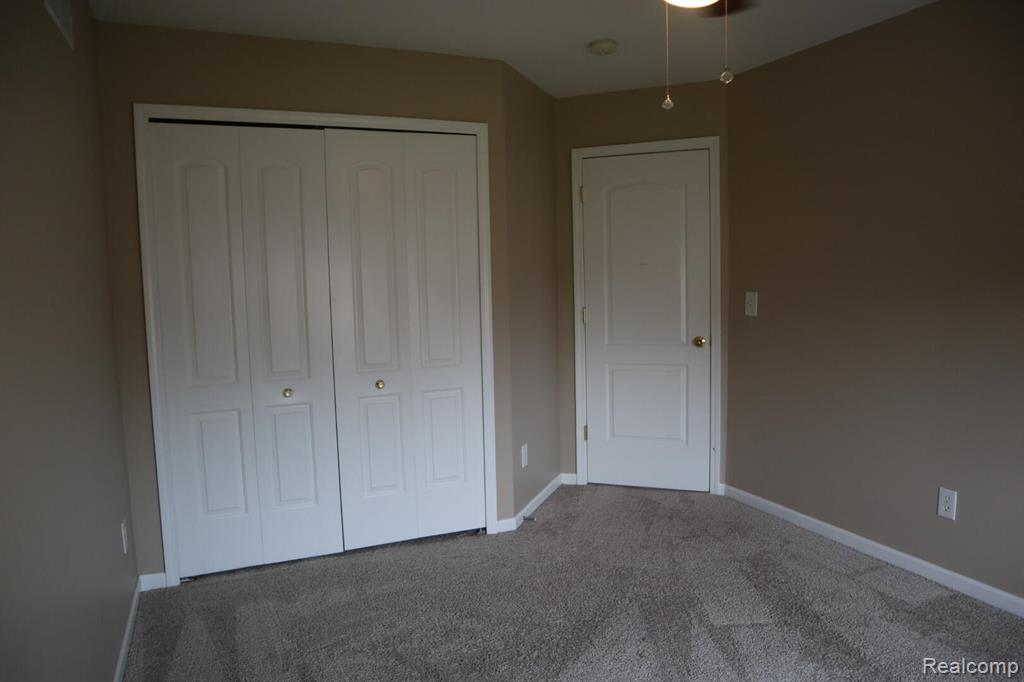 Unfurnished bedroom featuring carpet flooring and a closet