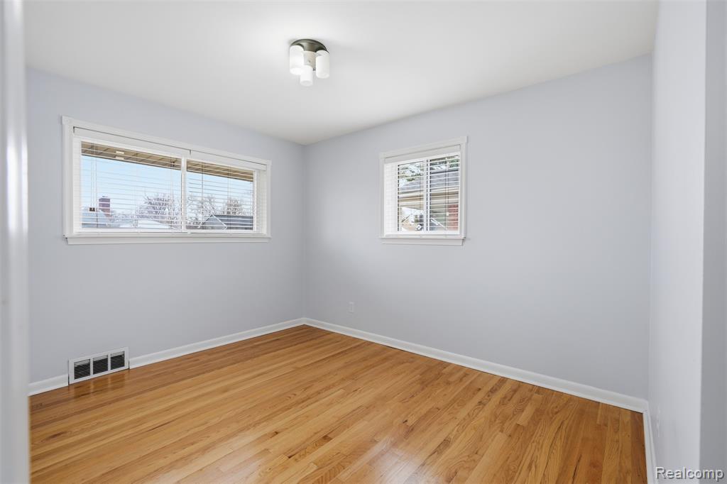 Spare room with light wood-style floors and baseboards
