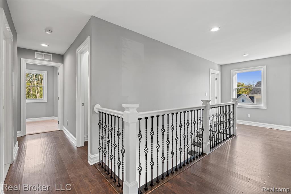 Hall featuring an upstairs landing, dark wood finished floors, and recessed lighting