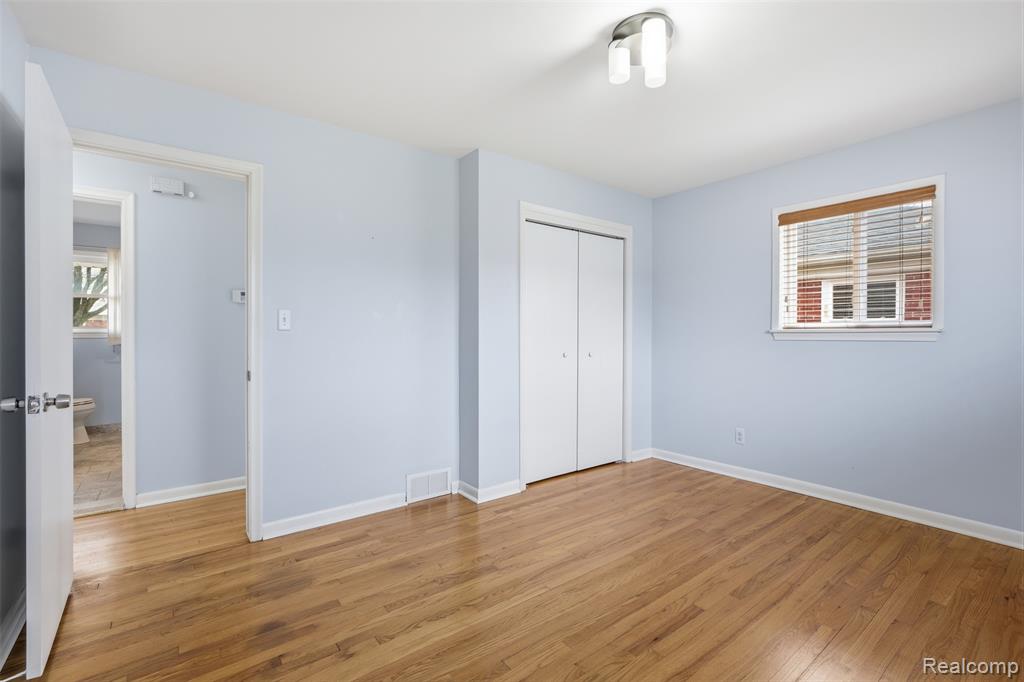 Unfurnished bedroom featuring light wood finished floors and a closet