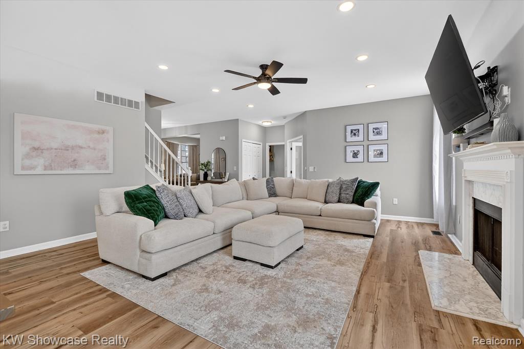 Dining space featuring stairs, light wood-style floors, a chandelier, a ceiling fan, and recessed lighting