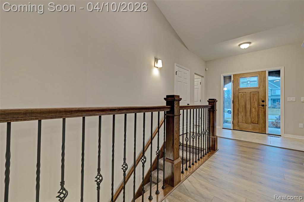 Entryway featuring light wood finished floors and lofted ceiling