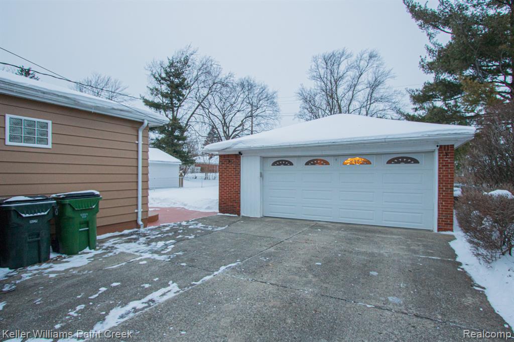 Snow covered garage featuring a garage