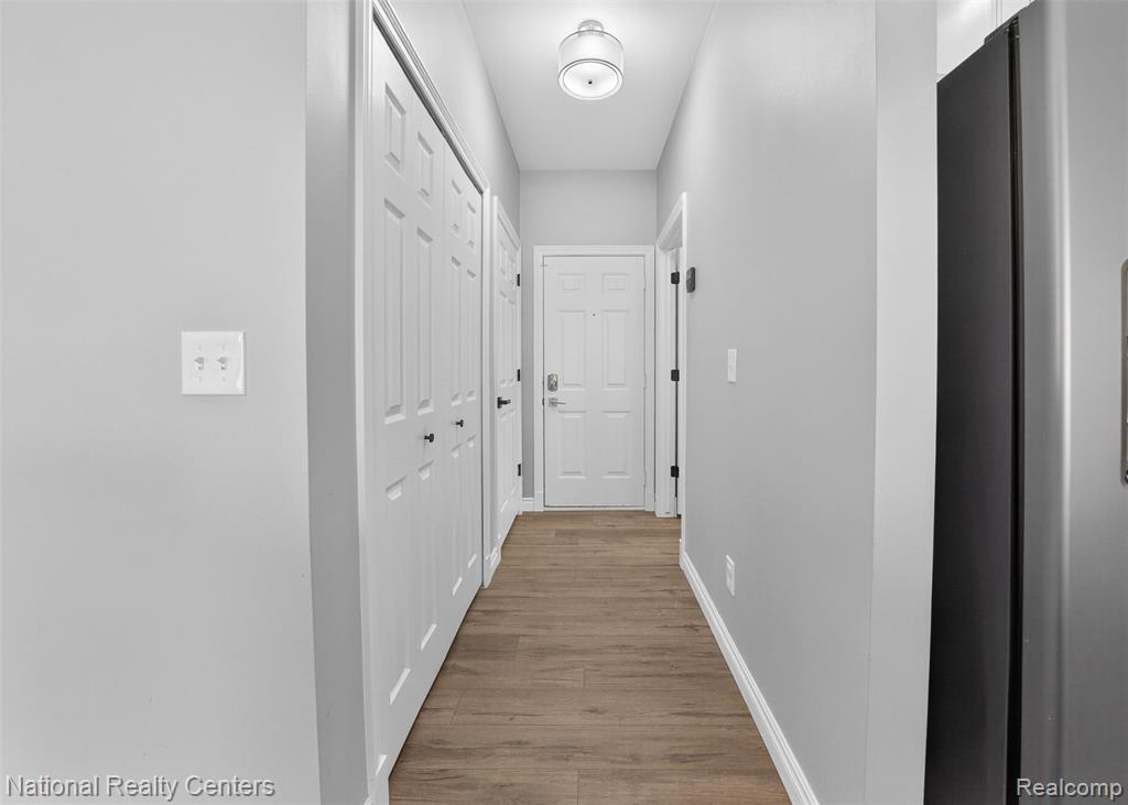 Hall with baseboards and light wood-style floors