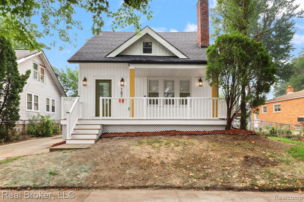 White vertical siding exterior with a dark shingle roof and a brick chimney