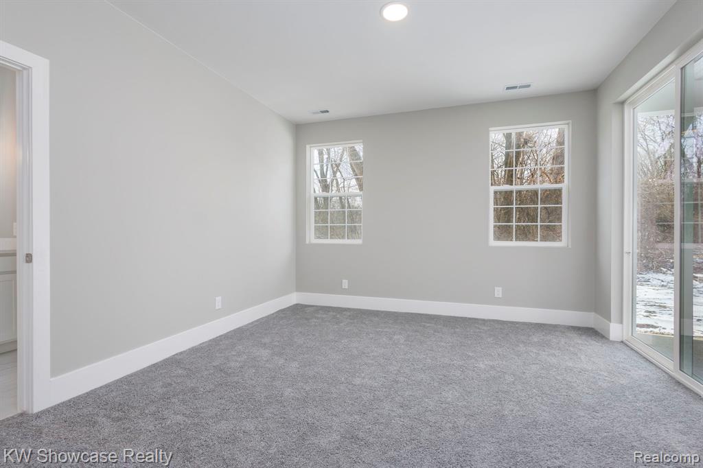 Primary Bedroom featuring carpet flooring, direct access to exterior covered patio.
