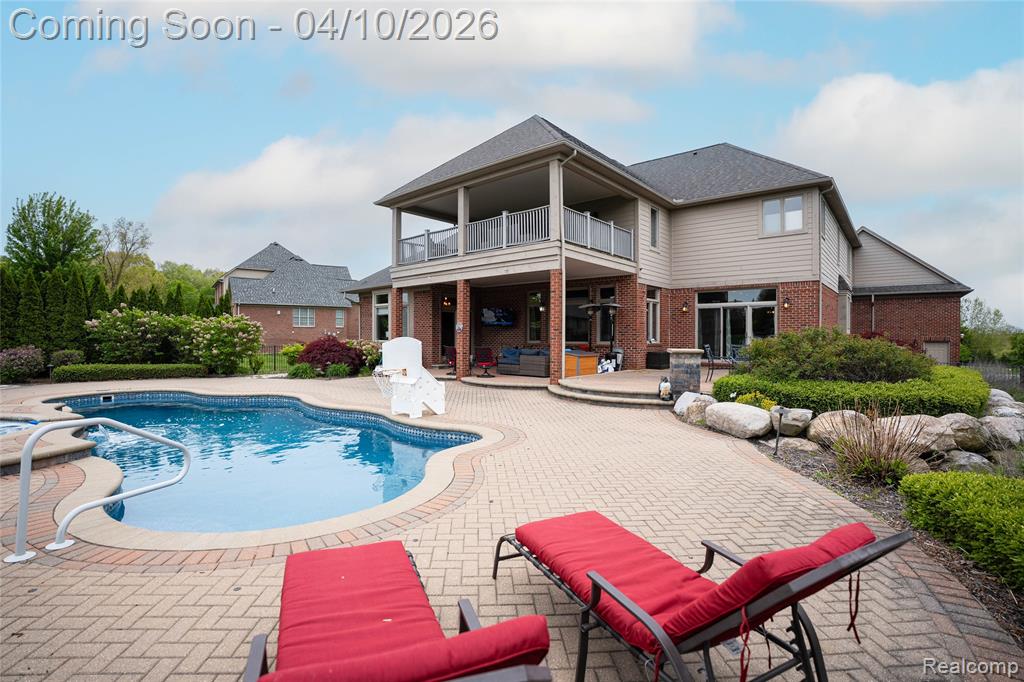 Swimming pool with a patio area, a balcony, and outdoor seating