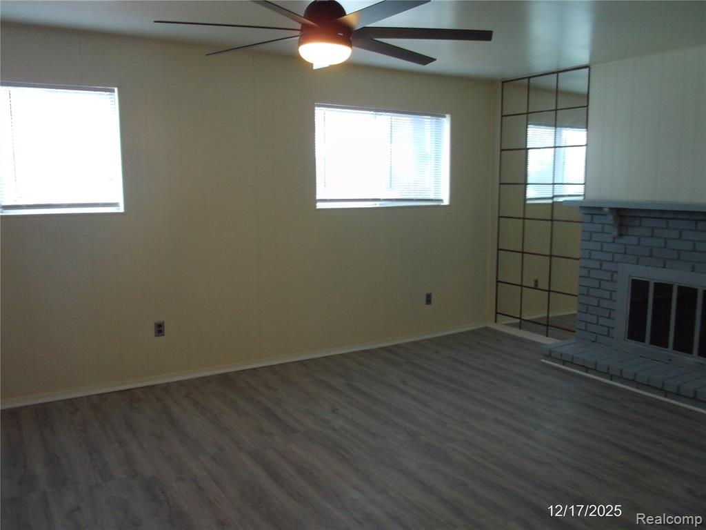 Kitchen featuring appliances with stainless steel finishes, dark wood-style floors, under cabinet range hood, backsplash, and gray cabinetry