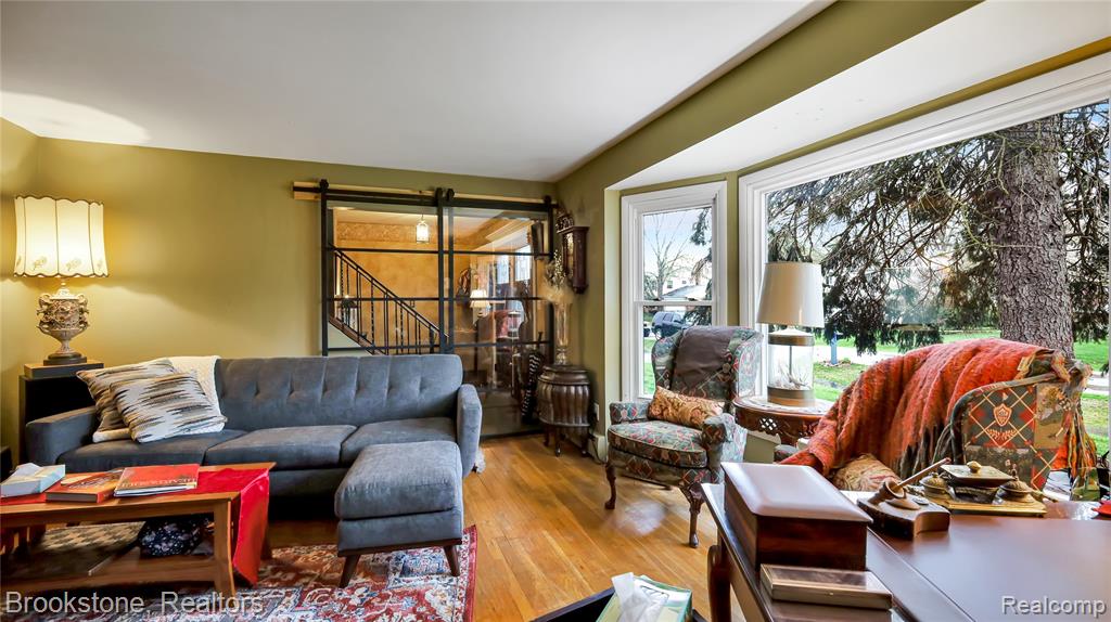 Living area with wood-type flooring and a barn door