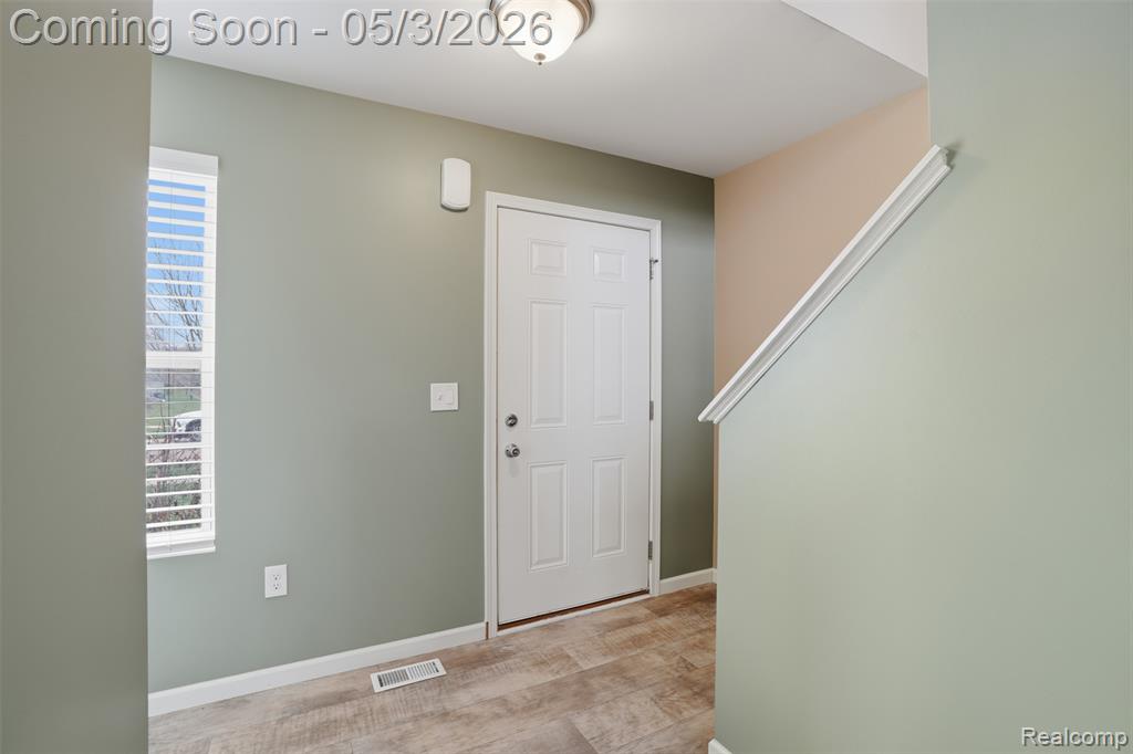 Foyer entrance with baseboards and light wood-type flooring