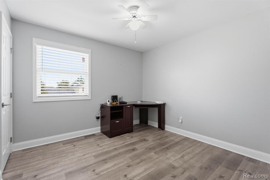 Unfurnished office featuring light wood-style floors and ceiling fan