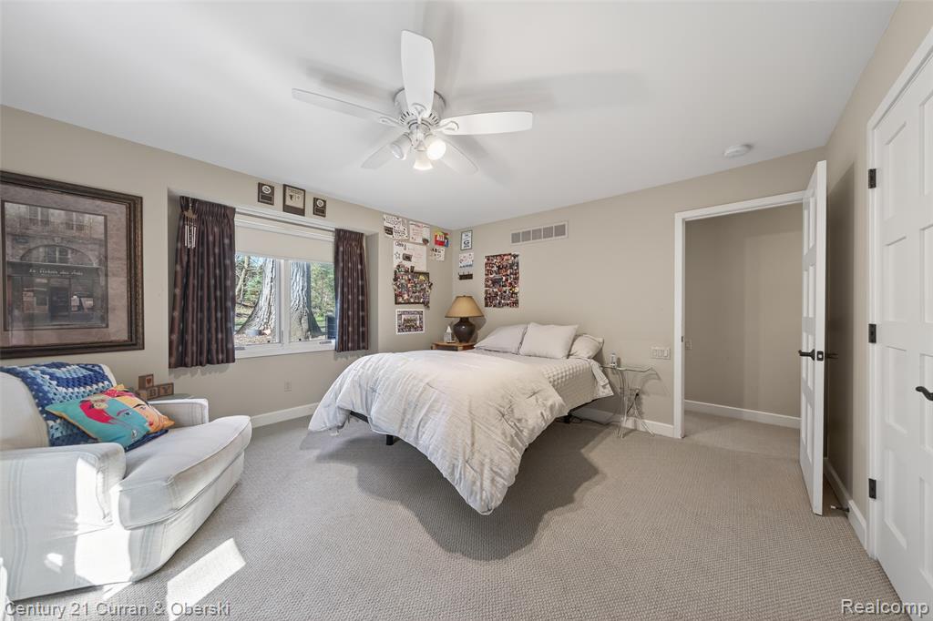 Bedroom with light carpet and ceiling fan