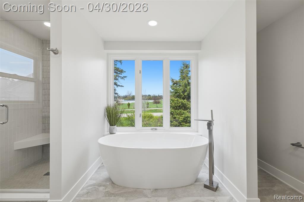 Primary Bathroom featuring a soaking tub and shower