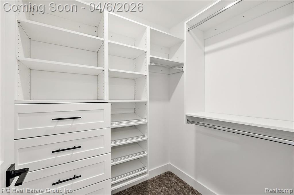 Walk in closet with dark carpet