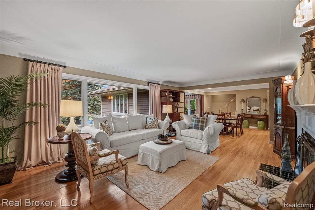 Living area featuring crown molding, recessed lighting, wood finished floors, and stairway