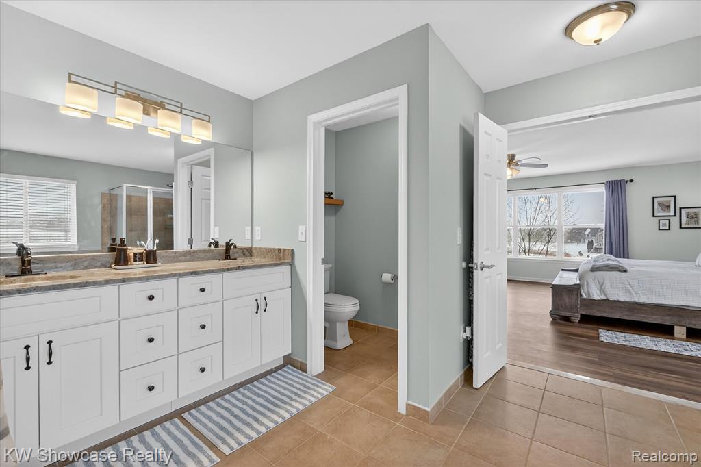 Full bath featuring a walk in closet, a stall shower, a garden tub, and tile patterned floors