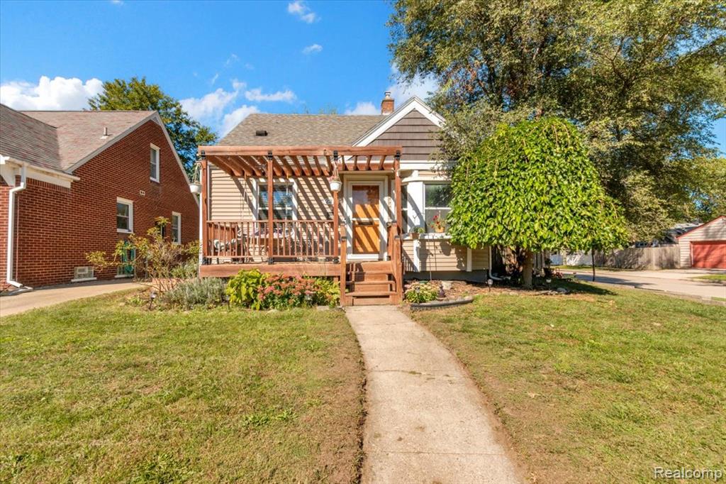 Wood-sided exterior with a covered porch featuring a wooden pergola and railing
