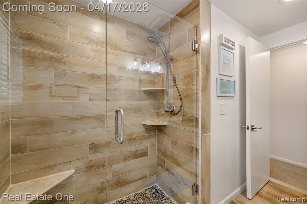 Full bath featuring a stall shower and light wood-type flooring