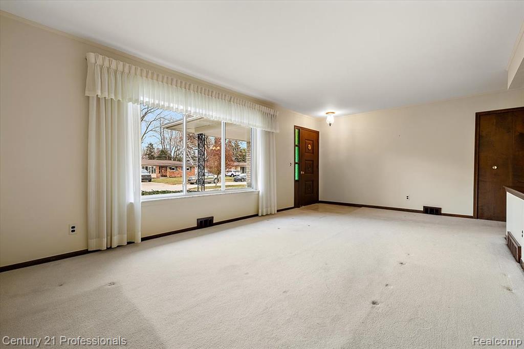 Carpeted empty room with baseboards
