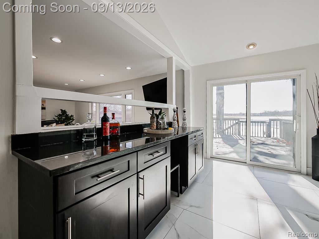 Dual tone kitchen featuring stainless steel appliances, dark stone counters, tasteful backsplash, recessed lighting, and a ceiling fan