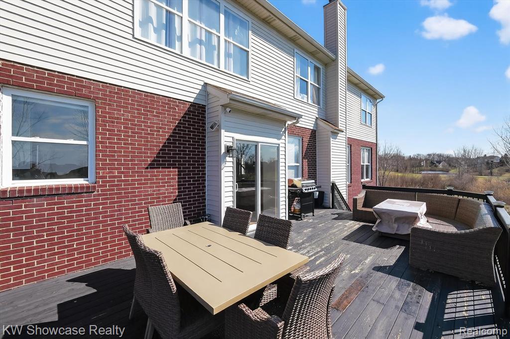 Wooden deck featuring a grill and outdoor dining space
