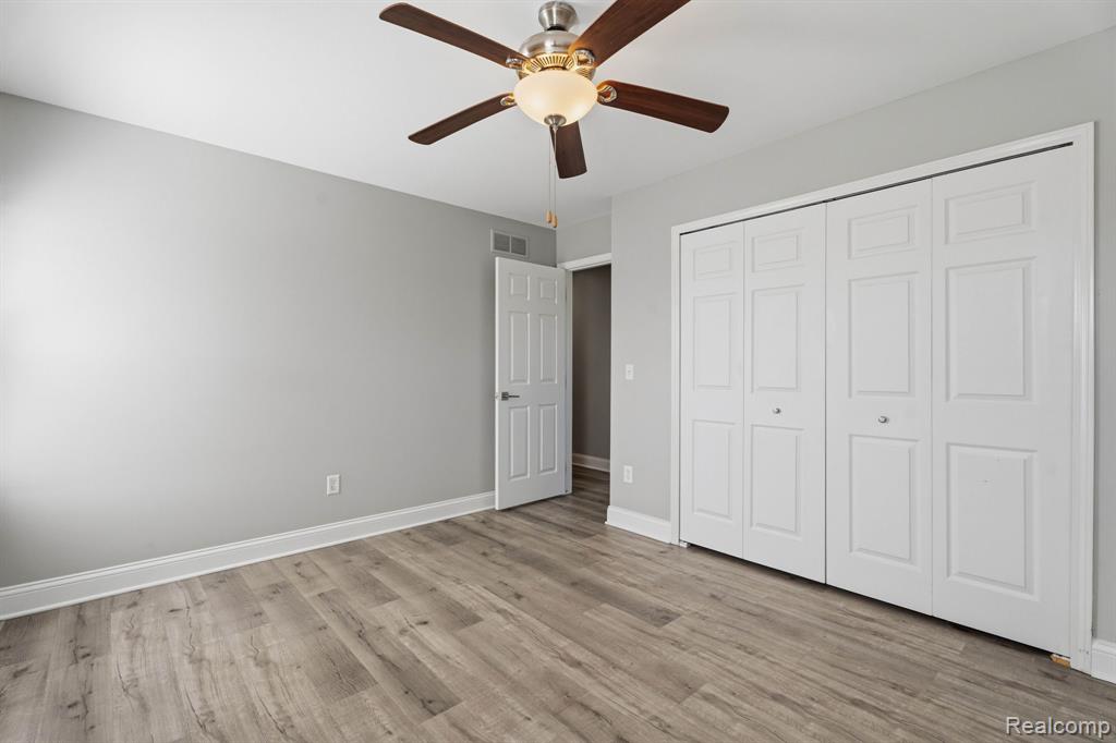 Unfurnished bedroom featuring a ceiling fan, a closet, and light wood-style floors