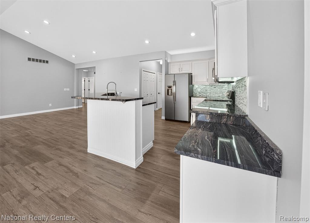 Kitchen with stainless steel appliances, white cabinetry, tasteful backsplash, recessed lighting, and light wood-style flooring
