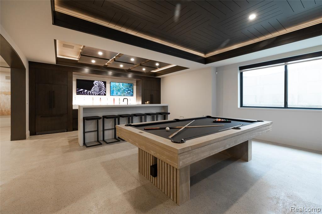 Playroom with pool table, wet bar, recessed lighting, a tray ceiling, and finished concrete floors