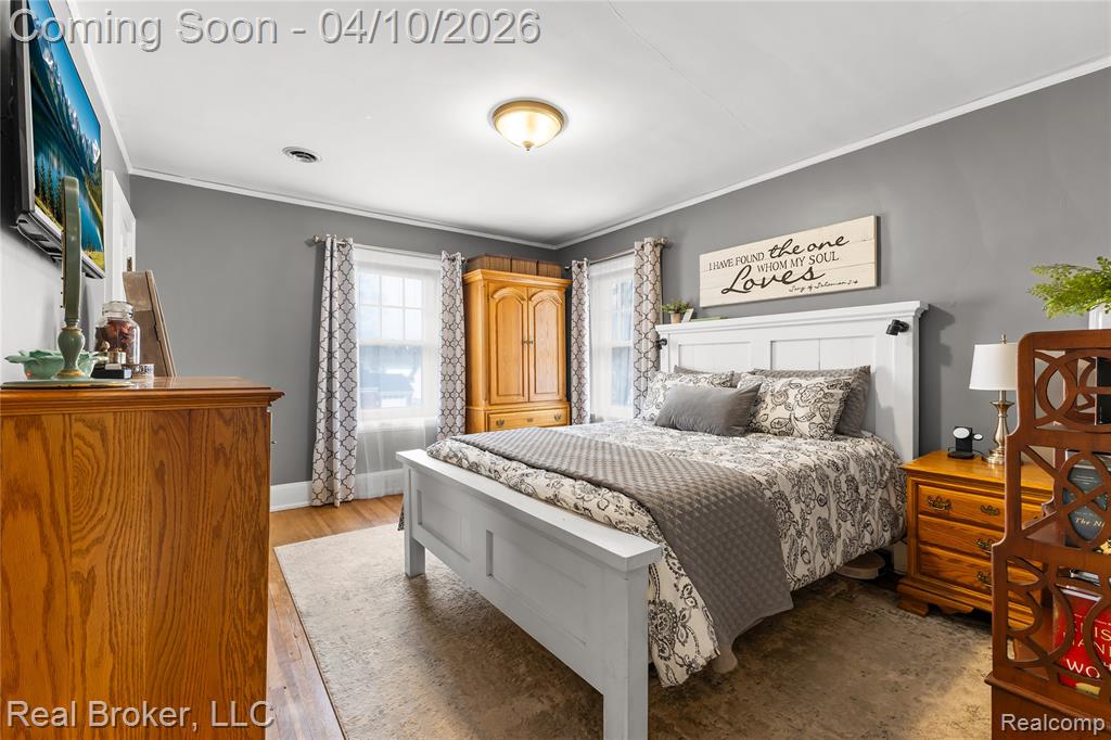 Bedroom with ornamental molding and light wood-type flooring