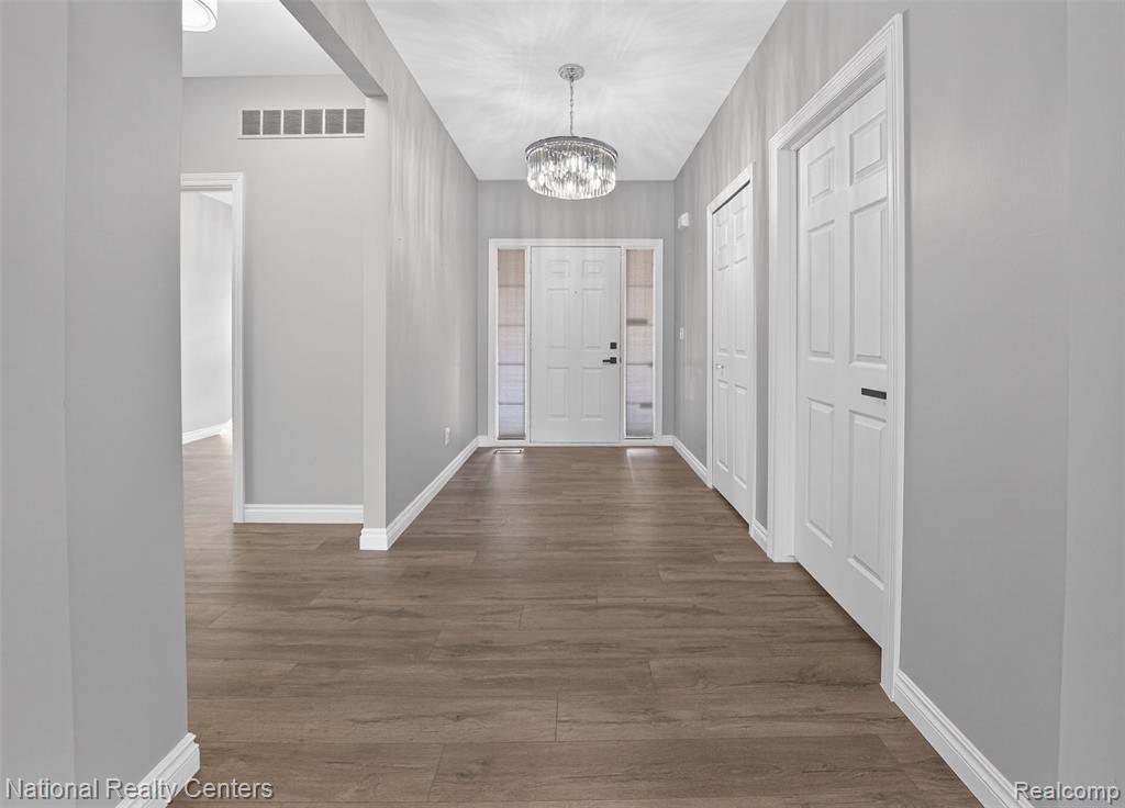 Entryway with hanging lights and wood finished floors