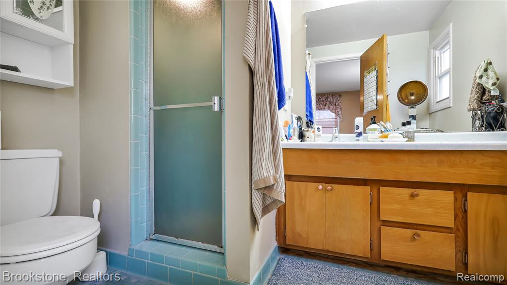 Full bath featuring a shower stall, vanity, and healthy amount of natural light