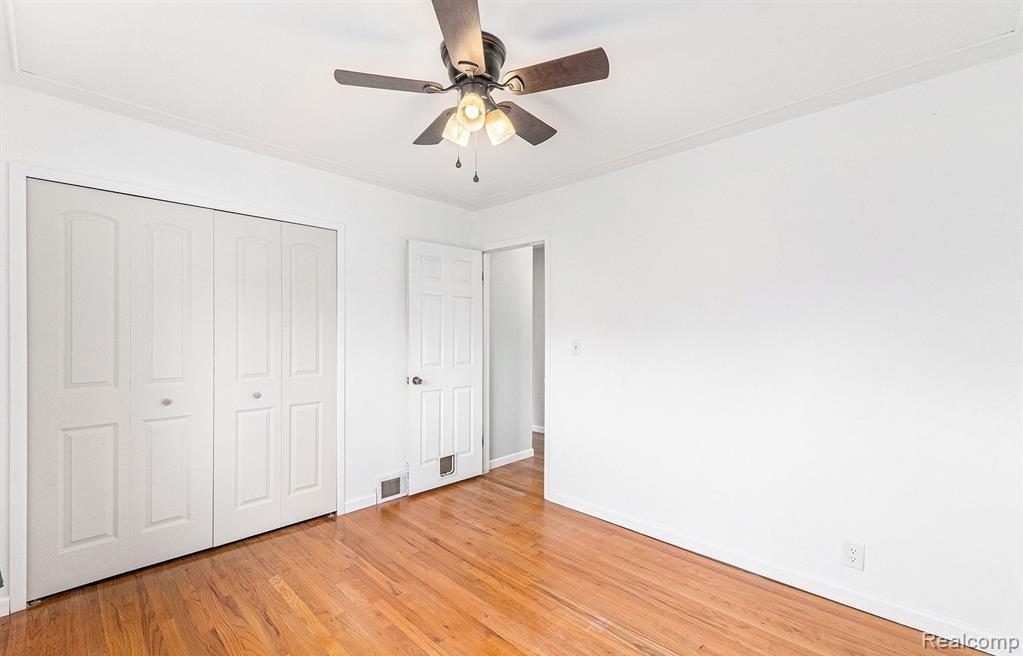 Unfurnished bedroom featuring a closet, a ceiling fan, and light wood finished floors