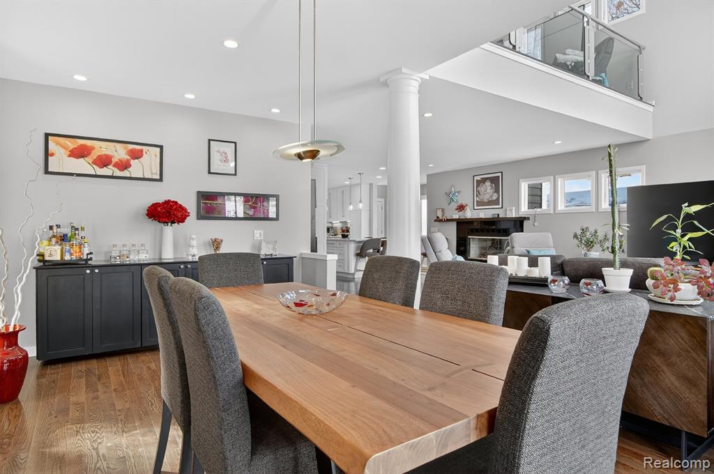 Dining space featuring dark wood-style floors, recessed lighting, and decorative columns