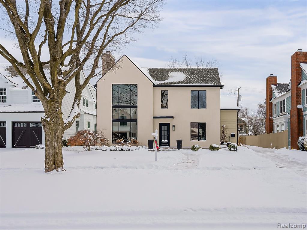 View of front facade with a chimney and stucco siding