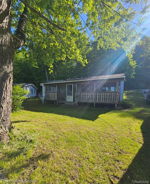 Ranch-style residence featuring a screened-in porch with wood railings and a front door with a storm door