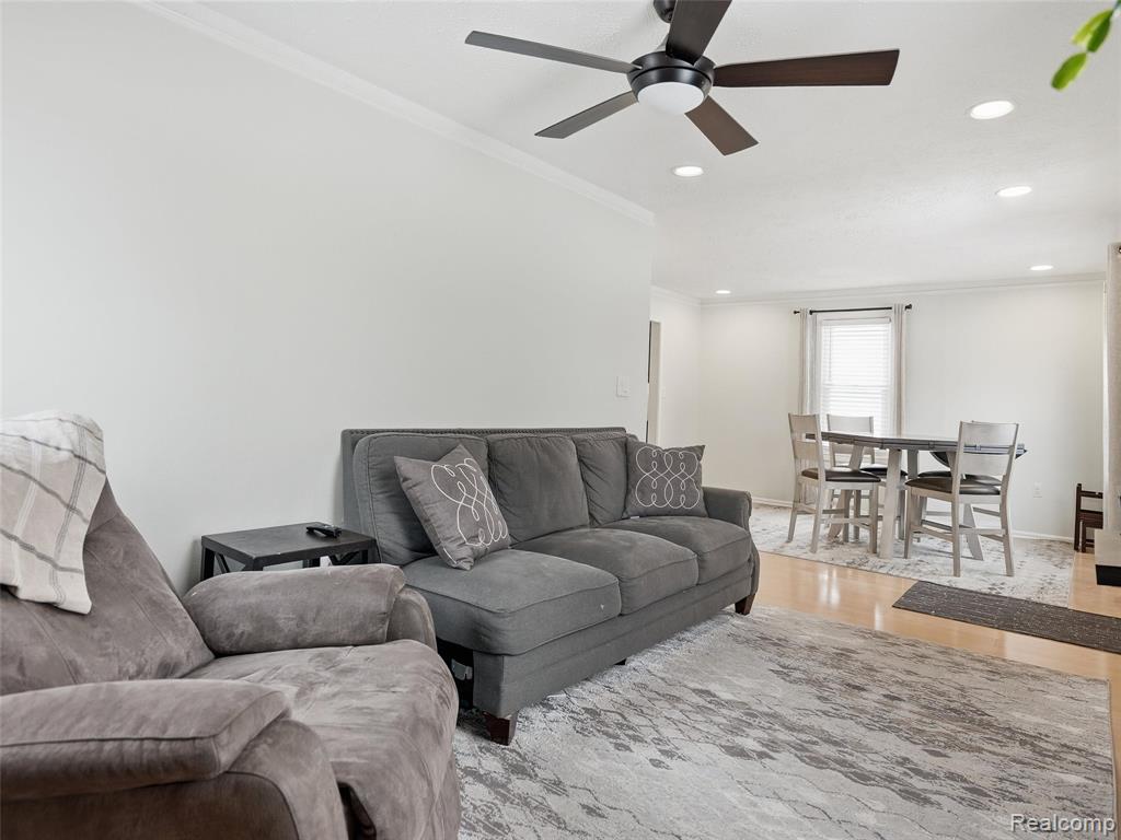 Living room featuring crown molding, light wood-style floors, recessed lighting, and ceiling fan
