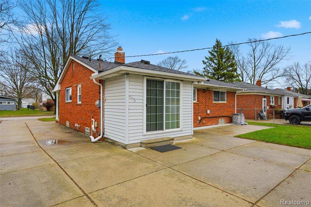 Rear view of property featuring brick siding and a chimney