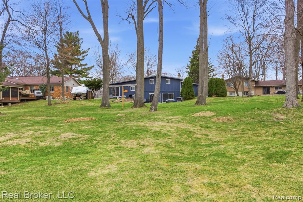 View of green lawn featuring a deck
